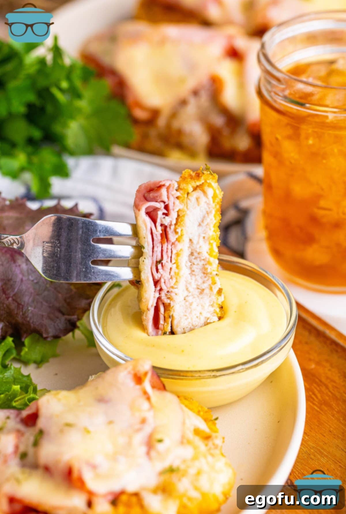 California Stuffed Chicken 12 A fork holding a bite of Malibu Chicken over the rest of the plate.