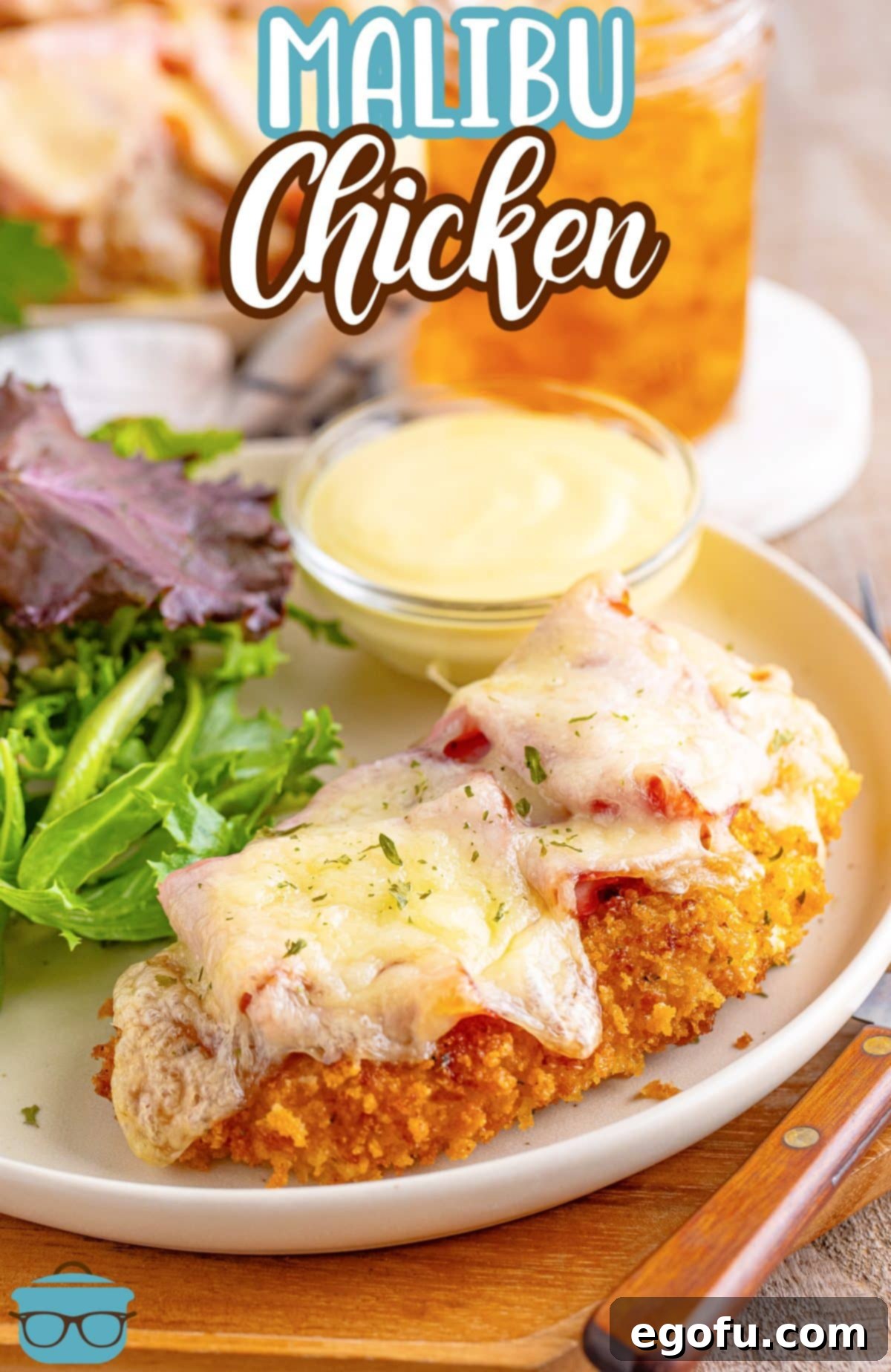 California Stuffed Chicken 3 Some Malibu Chicken with a salad and dipping sauce on a plate.