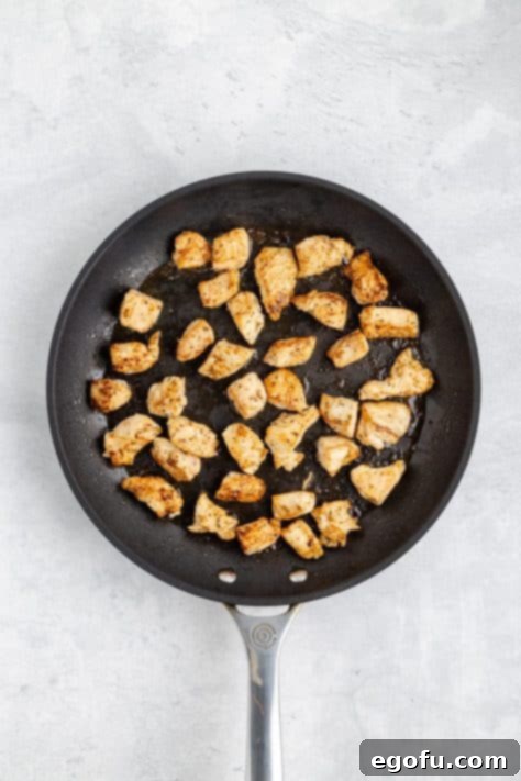 A skillet with cooked chicken.