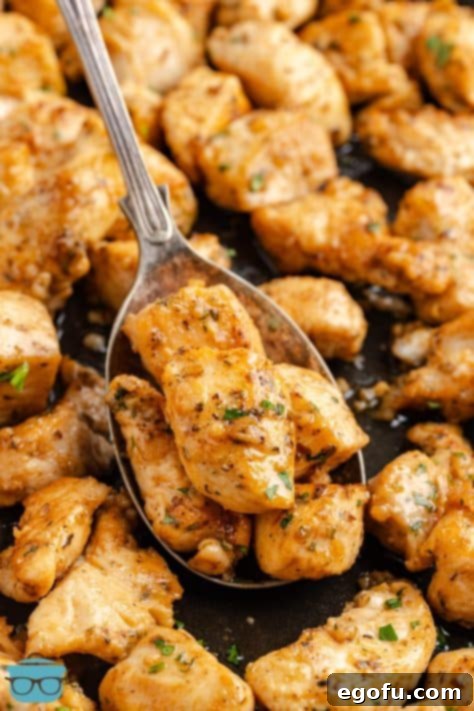 A spoon holding a scoop of Garlic Butter Chicken Bites above the rest.