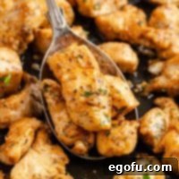 Looking down on a serving spoon getting a scoop of Garlic Butter Chicken Bites.
