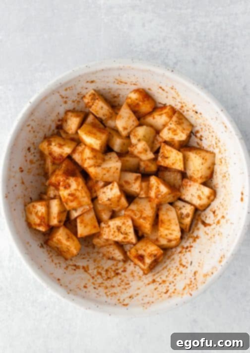 Crispy Air Fryer Breakfast Potatoes 9 A bowl of seasoned potatoes, ready for the air fryer.