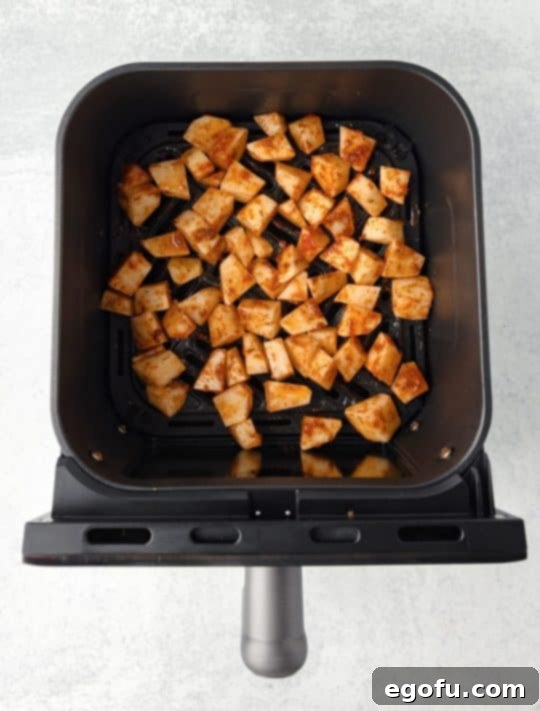 Crispy Air Fryer Breakfast Potatoes 10 Potatoes in an Air Fryer basket cooking, showing a single layer.