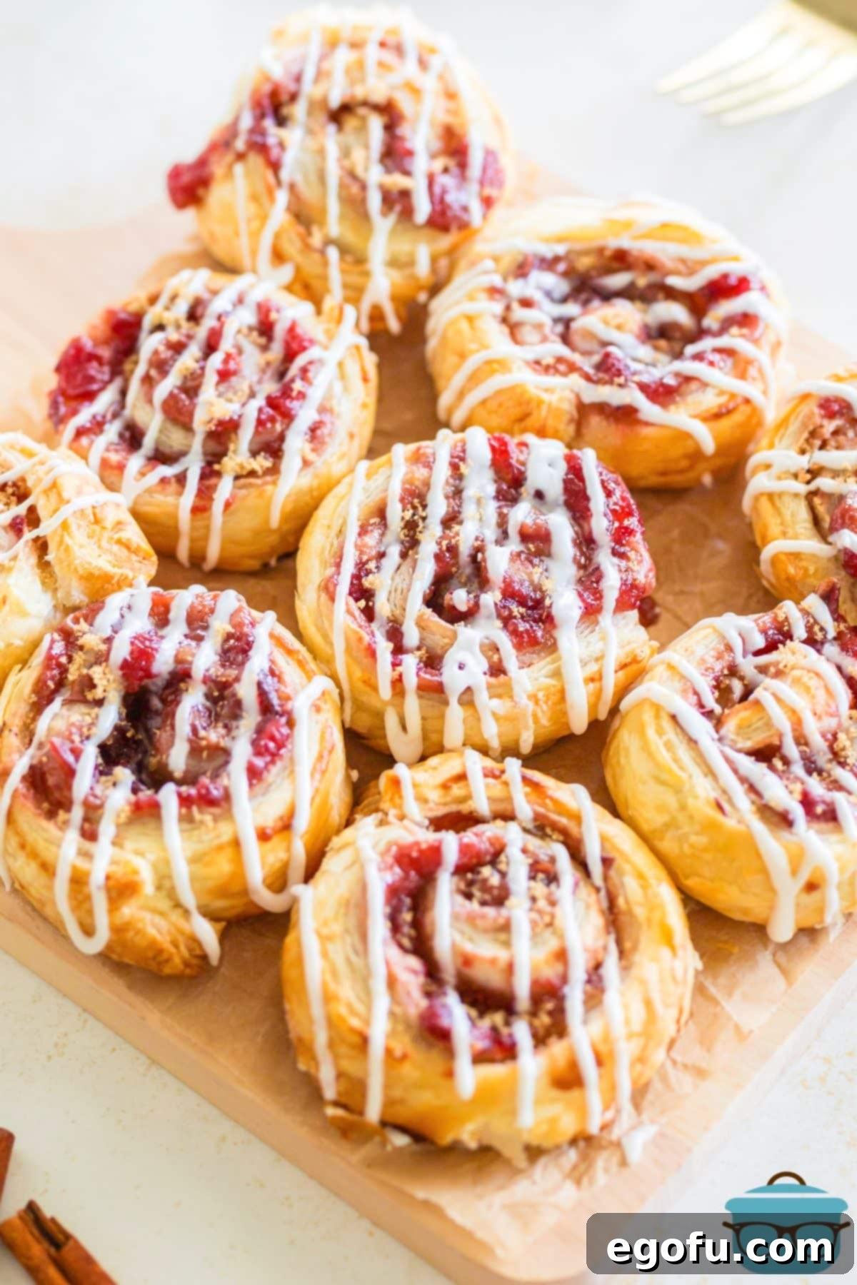 A close-up, top-down view of several elegant Cranberry Pinwheels, showing their flaky texture and sweet filling.