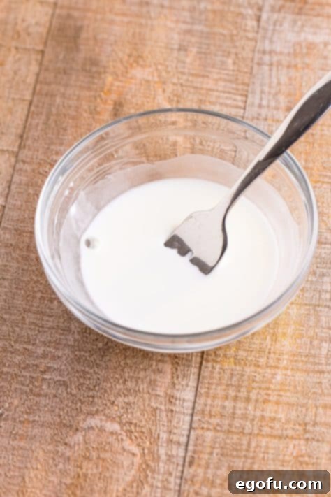Cornstarch slurry in a bowl with a whisk.