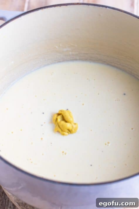 Dijon mustard being added.