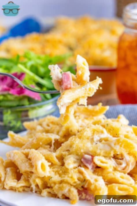 A fork holding a bite of Malibu Chicken Caserole.