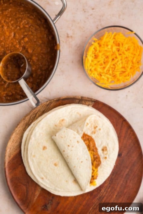 A close-up shot of a hand expertly folding a burrito, tucking in the sides to create a neat and secure wrap.