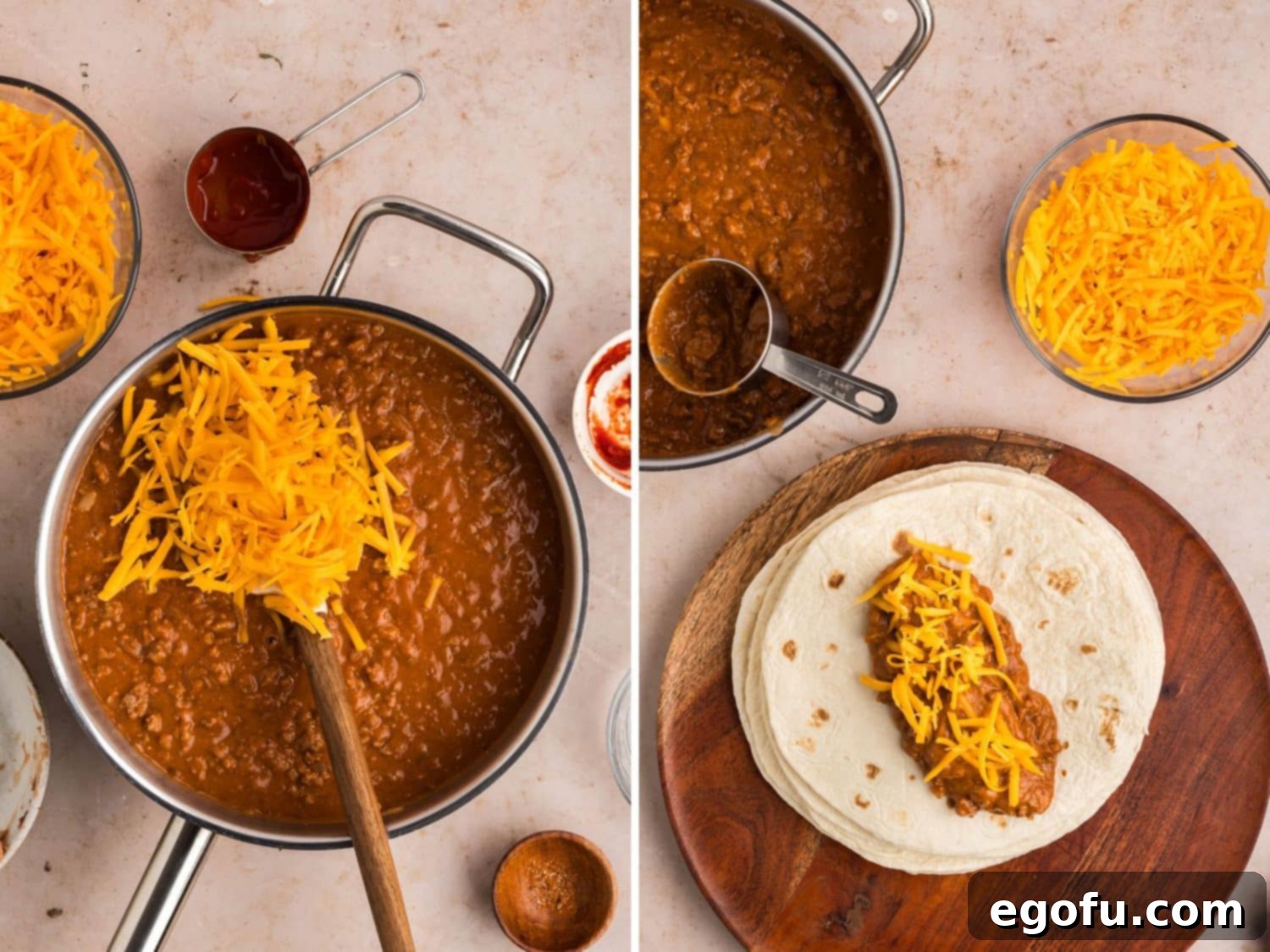 A generous amount of shredded cheddar cheese being added to the hot chili beef mixture in a skillet, with a few assembled burritos waiting nearby.