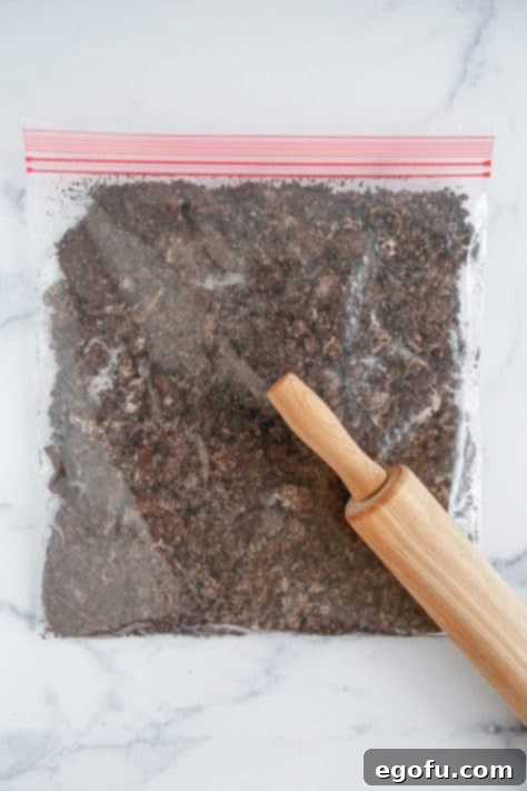 A rolling pin crushing some Oreos in a ziptop bag.