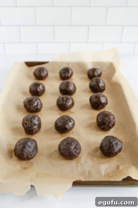 Oreo Truffles on a parchment lined sheet.