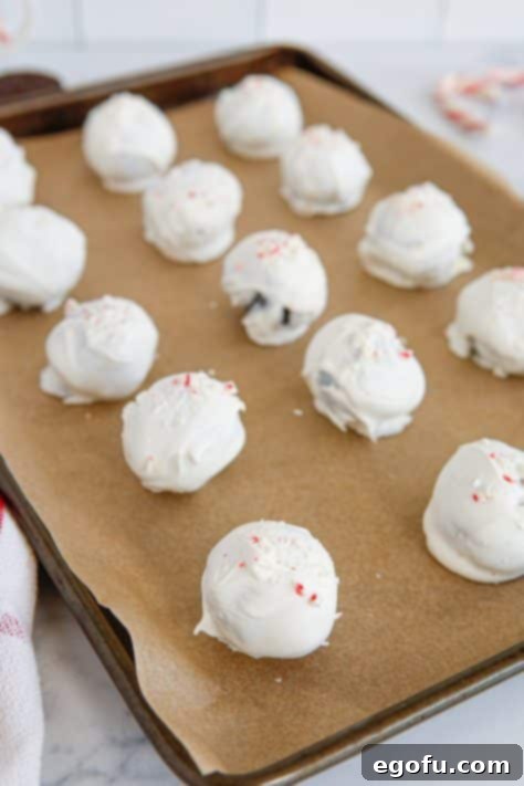 White chocolate covered Oreo cookie balls with crushed peppermints on top.