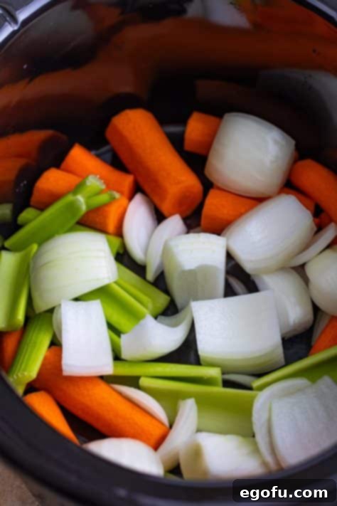 Set-It-and-Forget-It Corned Beef 11 Carrots, celery and onions in a Slow Cooker, forming the base.