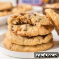 Looking closely at a small stack of Snickers Cookies with the top one missing a bite.