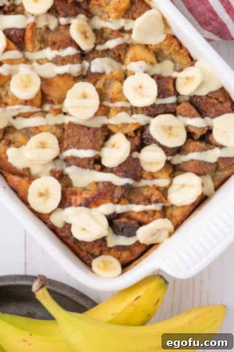 Banana slices layered on top of the baked dessert, with a rich vanilla sauce drizzled over it.