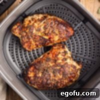 Flavorful Air Fryer Turkey Tenderloin 8 Looking down on an Air Fryer basket with two Turkey Tenderloins.