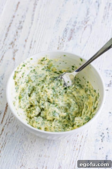A bowl with butter, parsley, garlic, parmesan, salt, and pepper.