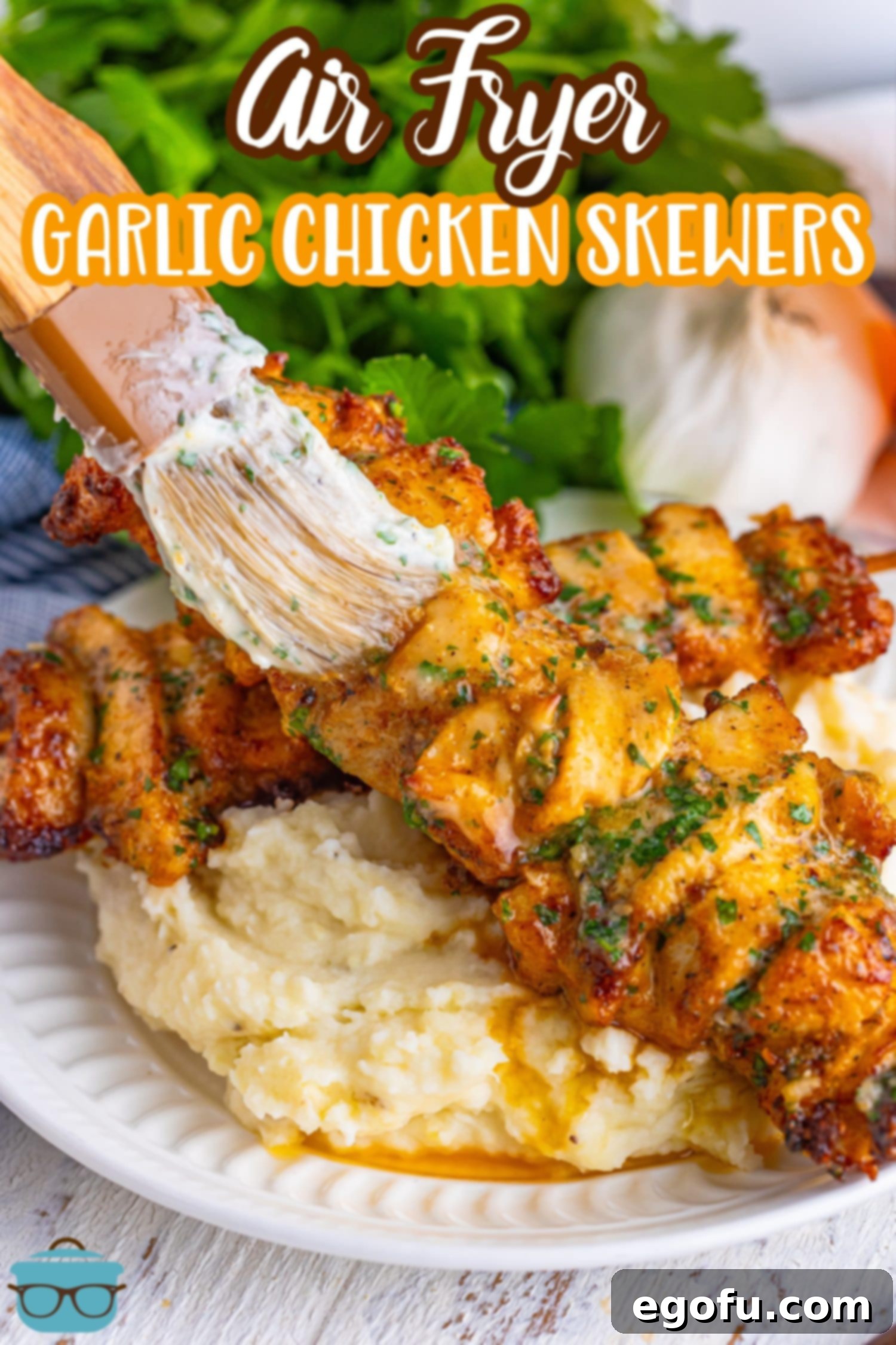 A plate of freshly cooked Garlic Parmesan Chicken Skewers being brushed with extra garlic butter sauce for added flavor and shine.