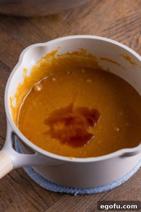 Crispy Peanut Butter Dream Bars 19 Vanilla extract being added to a pot.