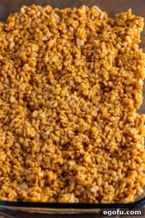 Crispy Peanut Butter Dream Bars 21 Pressed down rice krispie mixture in a baking dish.