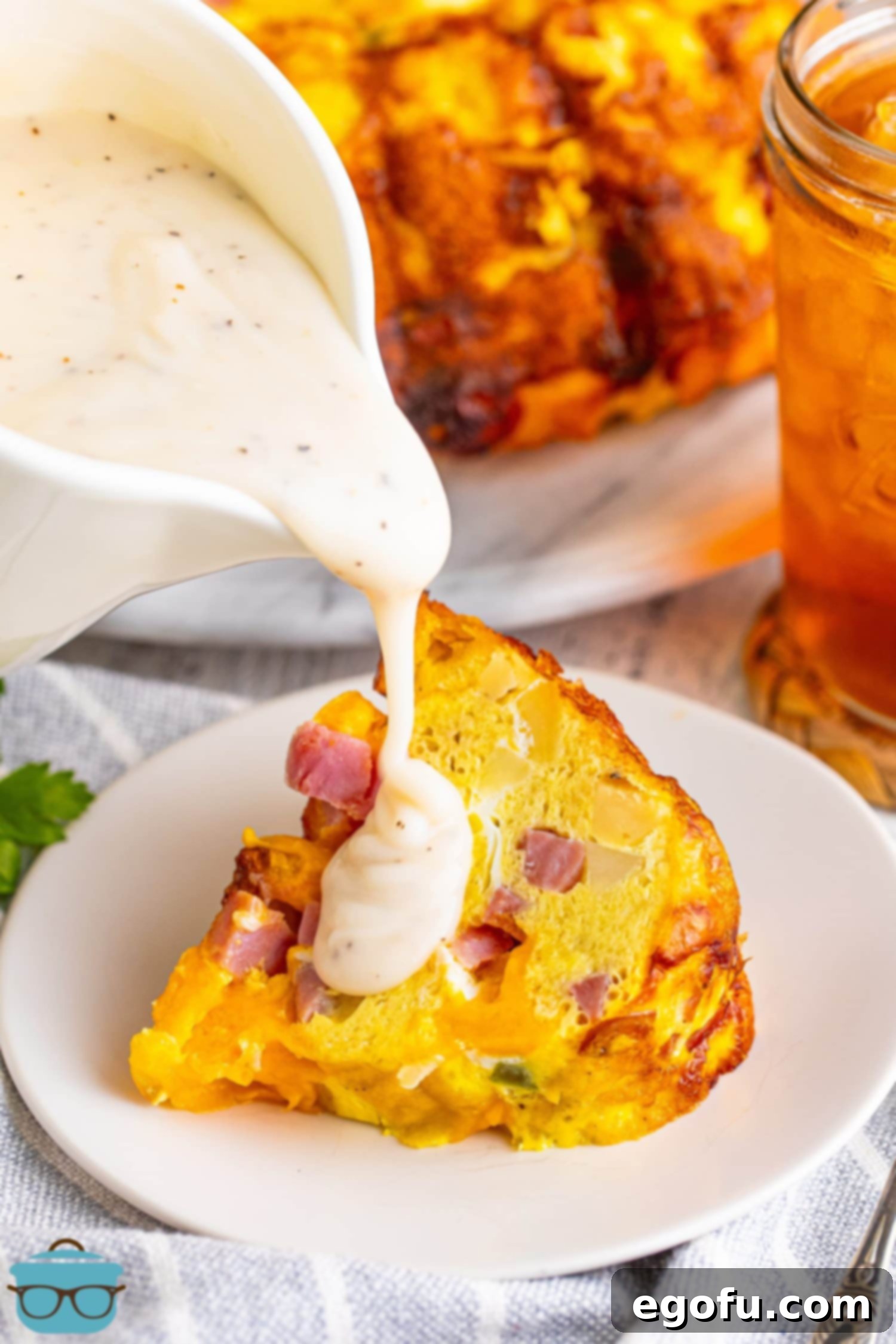 Rich breakfast gravy being generously poured over a delectable slice of the Breakfast Bundt Cake, ready to be served.