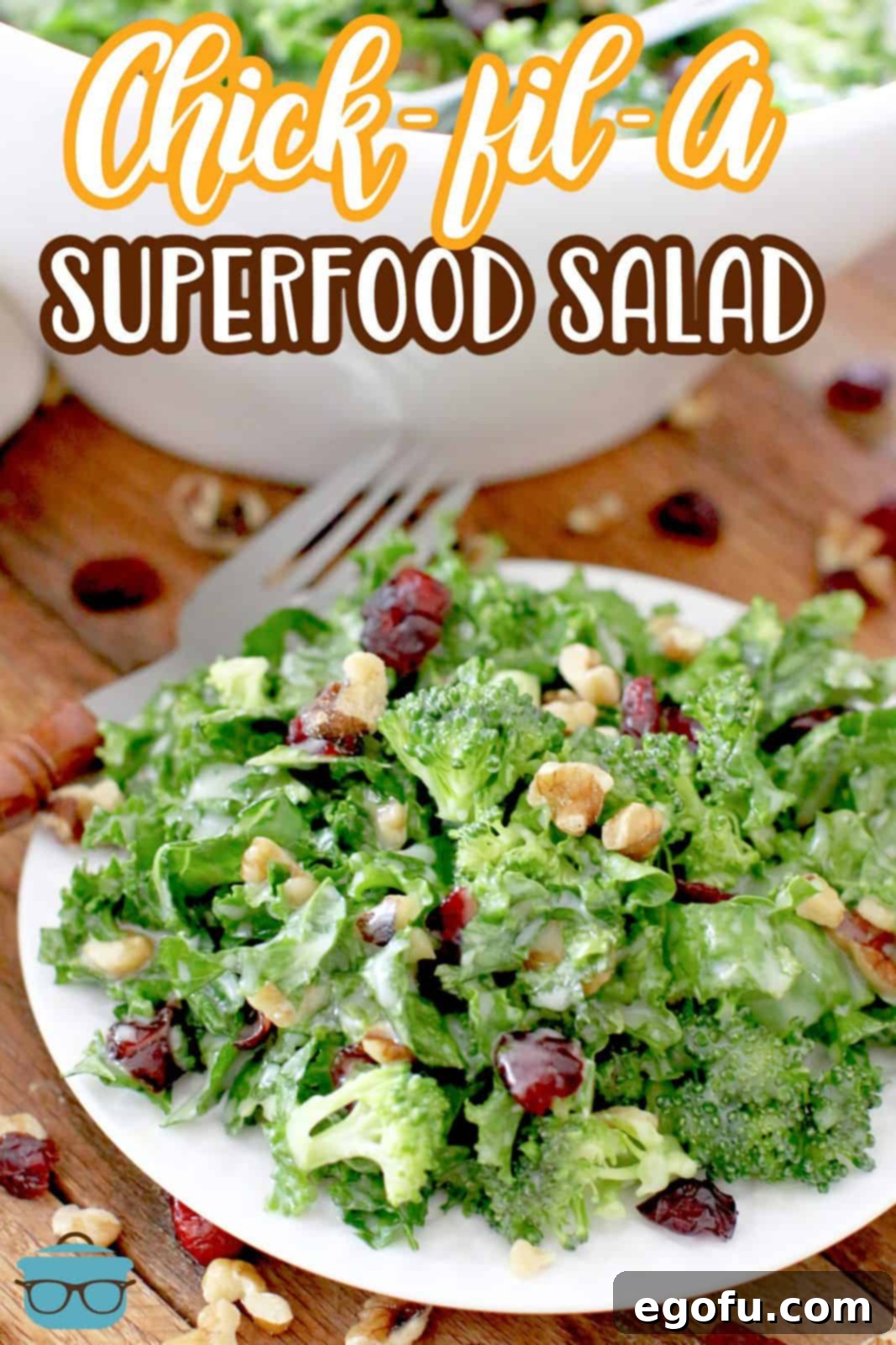 A close-up shot of the Chick-fil-A inspired Superfood salad on a small round white plate, artfully scattered with dried cranberries and chopped walnuts.