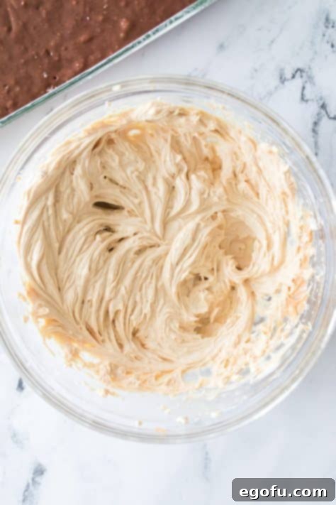 A bowl with softened cream cheese, butter, peanut butter, and vanilla extract.
