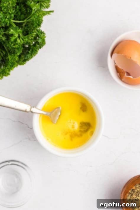 A ramekin with egg and water, whisked to form an egg wash.