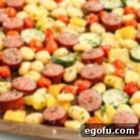 One-Pan Sausage and Gnocchi Bake 9 A close-up view of a sheet pan filled with golden-brown gnocchi, sliced smoked sausage, and colorful roasted vegetables, perfectly cooked and lightly caramelized.