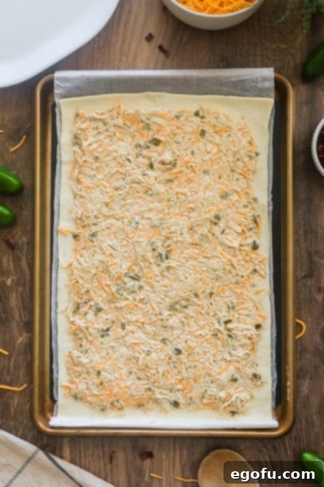 Cream cheese mixture on a puff pastry dough sheet.