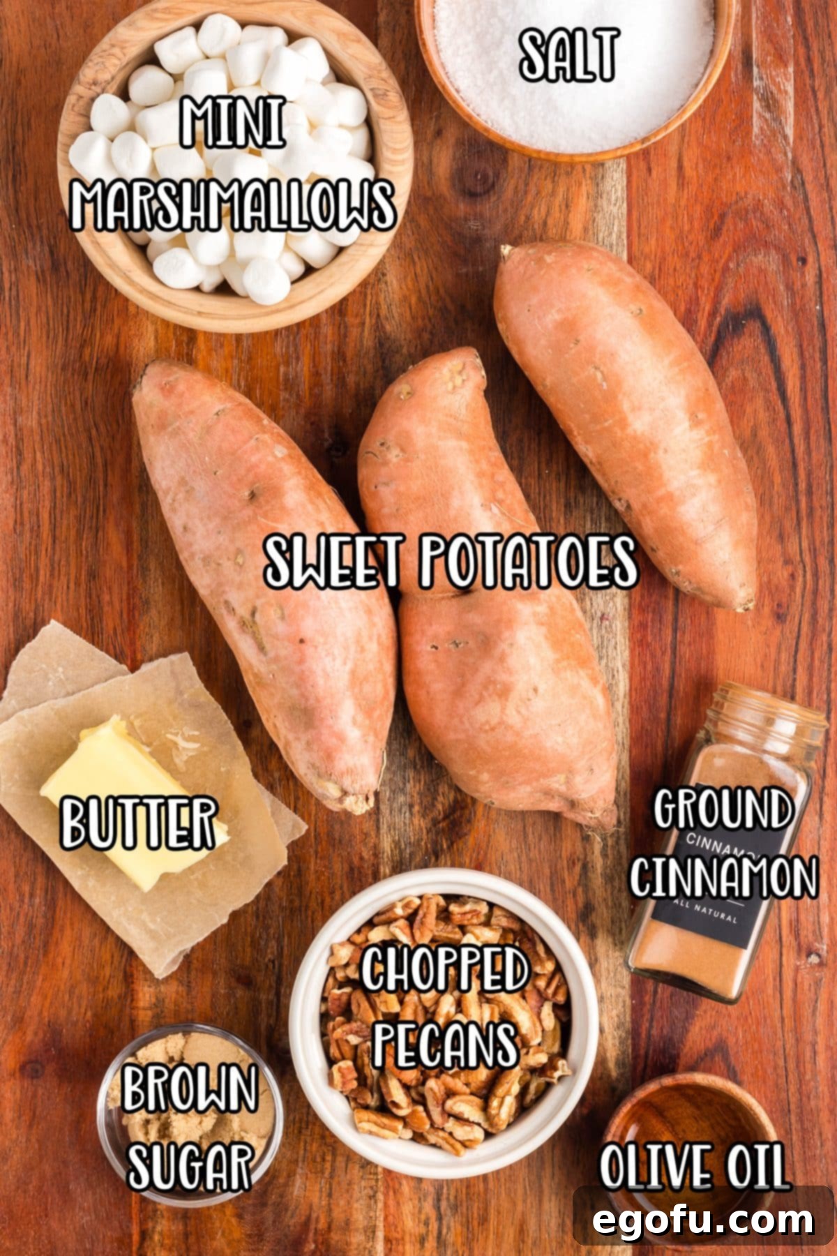 Sweet potatoes, mini marshmallows, butter, olive oil, brown sugar, cinnamon, salt, and chopped pecans laid out as ingredients.