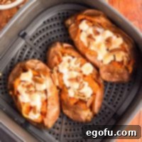 Three Air Fryer Baked Sweet Potatoes in an Air Fryer basket.
