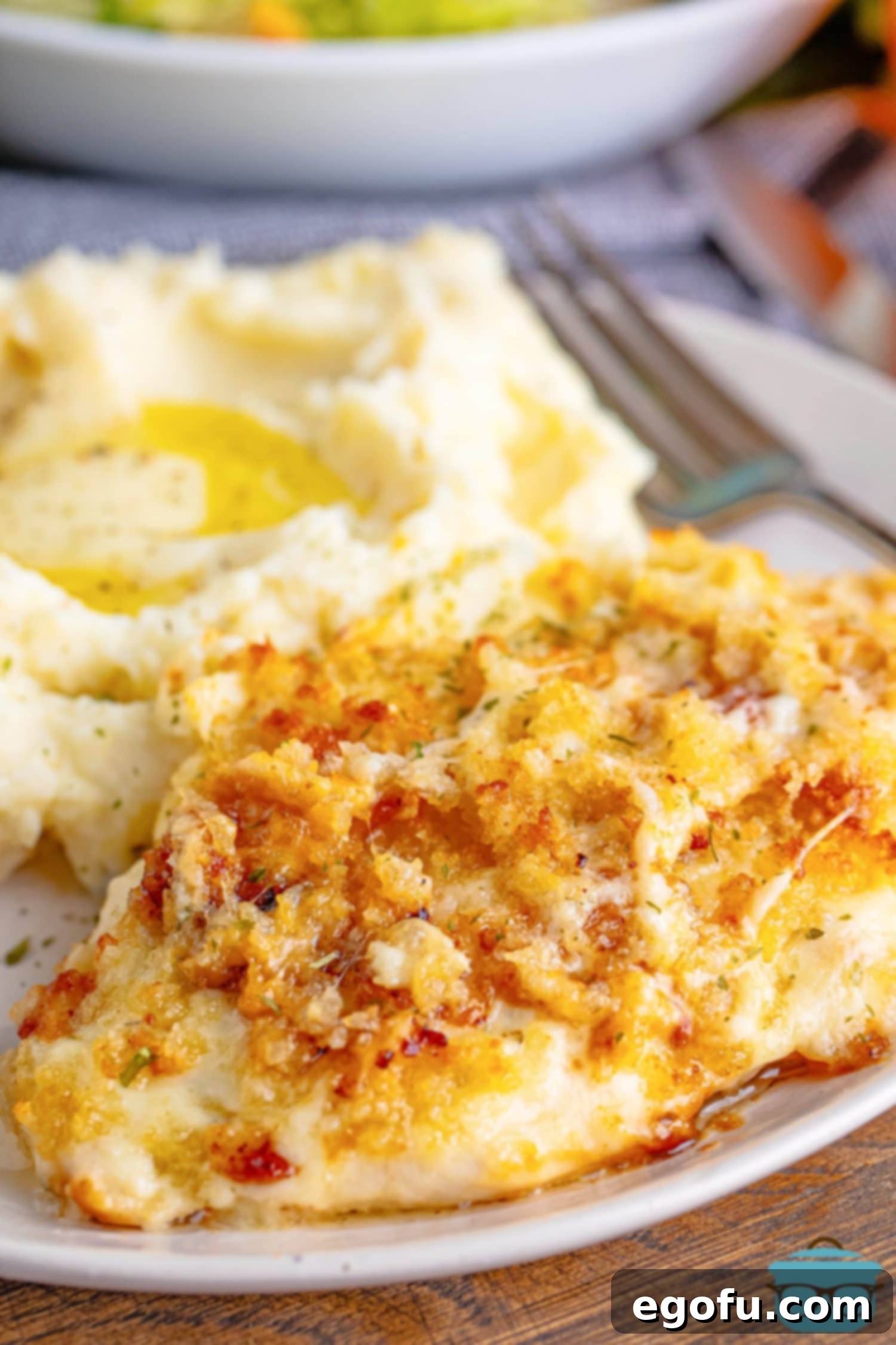 Longhorn's Crispy Parmesan Crusted Chicken 2 A plate of Longhorn Parmesan Crusted Chicken with a pile of mashed potatoes.