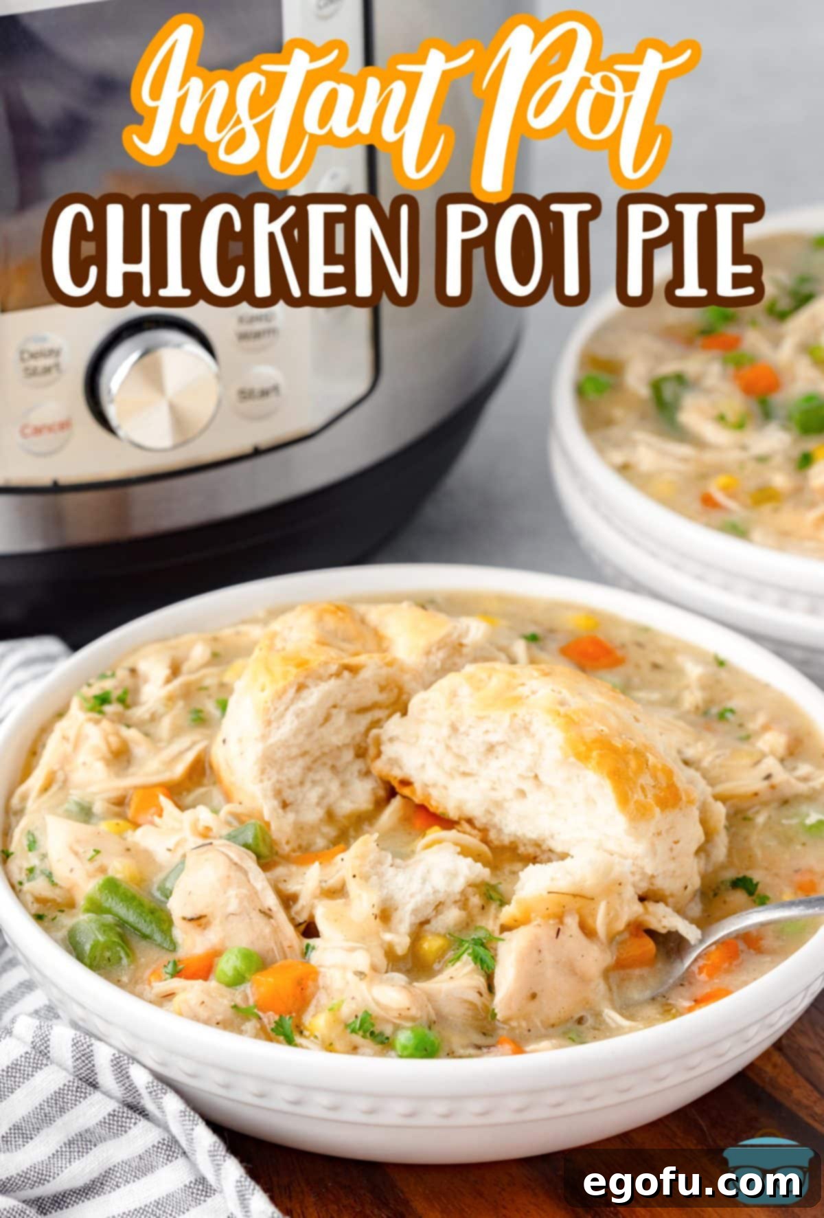 A few bowls of Instant Pot Chicken Pot Pie, each garnished with a freshly baked biscuit, arranged appealingly.