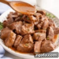 Sauce being spooned over Beef Tips.