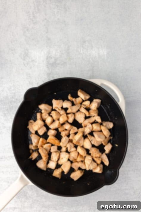 Cooked chicken pieces in a skillet.