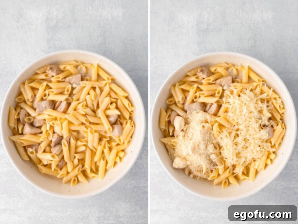 Mozzarella and parmesan cheese being added to the pasta and chicken mixture in a bowl.
