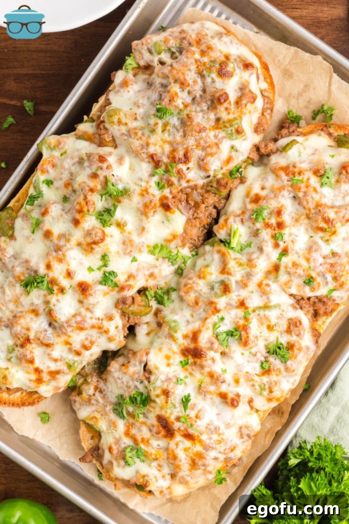 A lined baking sheet with slices of Philly Cheesesteak Garlic Bread. 