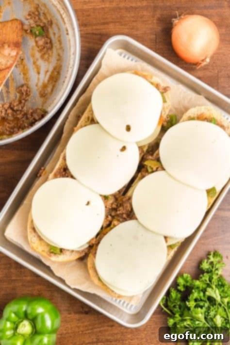 Layers of meat and cheese on bread.