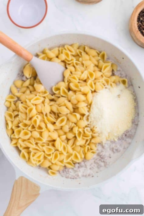 Pasta and cheese added to skillet.