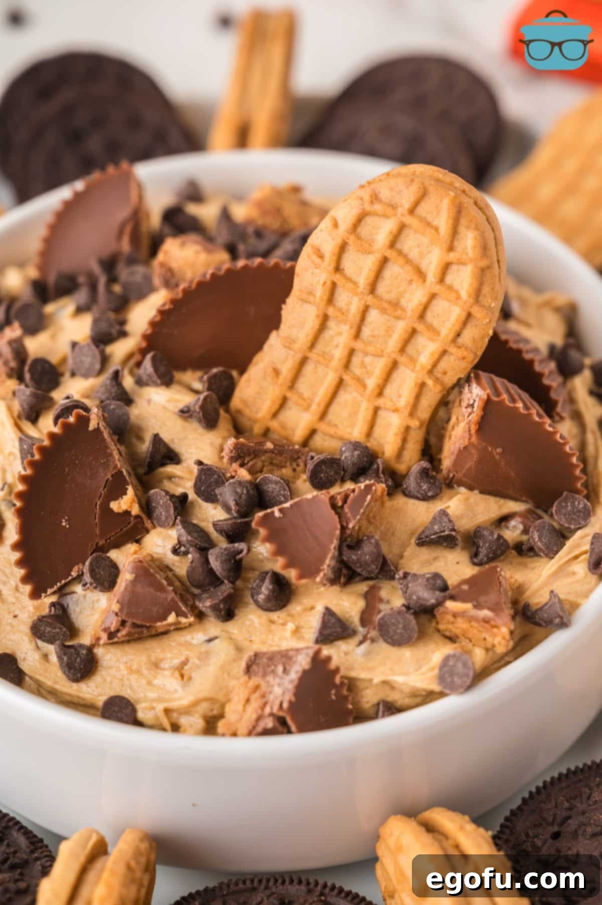 A close-up shot of creamy Peanut Butter Fluff in a bowl, with a Nutter Butter cookie dipped into it, highlighting its rich texture.