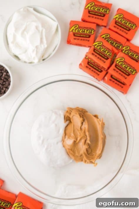 Peanut butter and marshmallow cream being mixed together in a bowl.