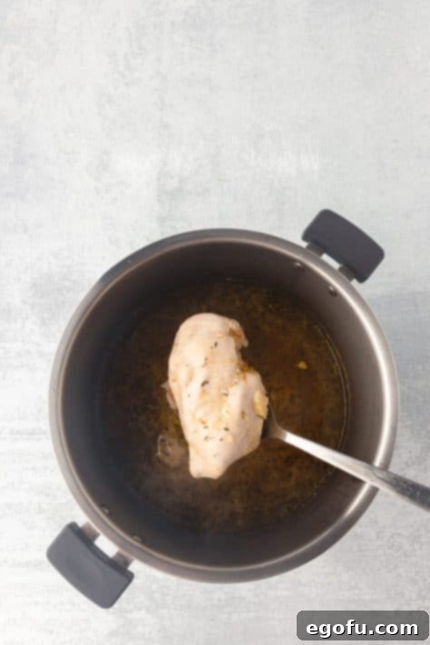 Comforting Instant Pot Chicken and Rice Soup 5 Chicken being removed from the Instant Pot.