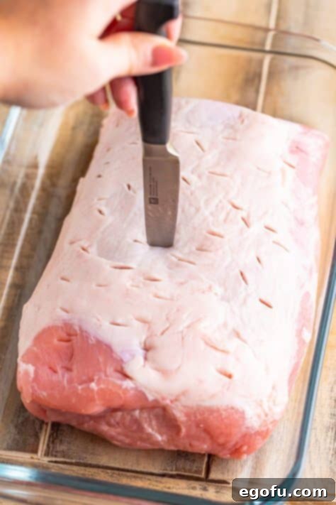 A knife poking holes in a roast.