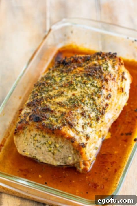 An herb crusted roast resting in a dish.
