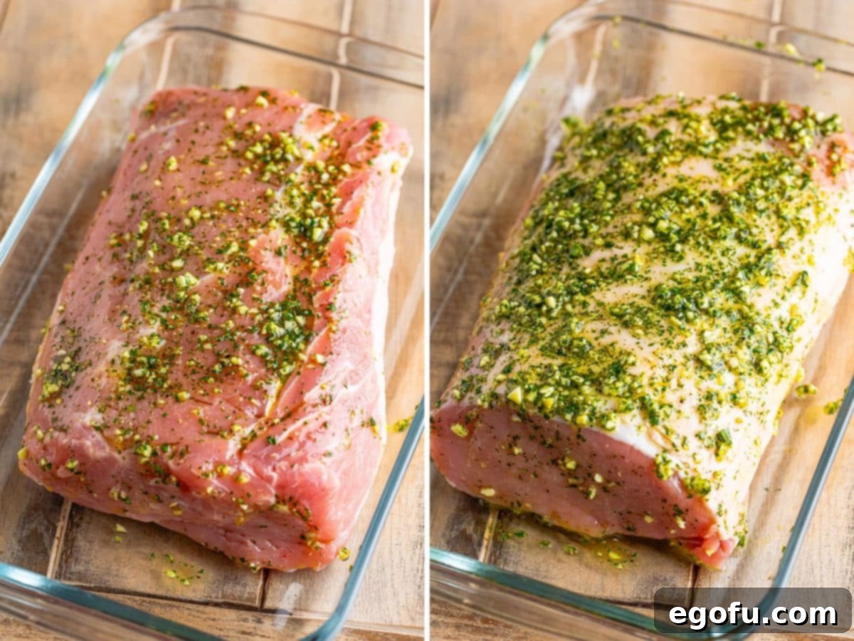 A pork loin being coated completely in the vibrant green herb mixture.