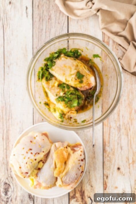 Zesty Cilantro-Lime Chicken 16 Chicken thighs being added to a marinade bowl.
