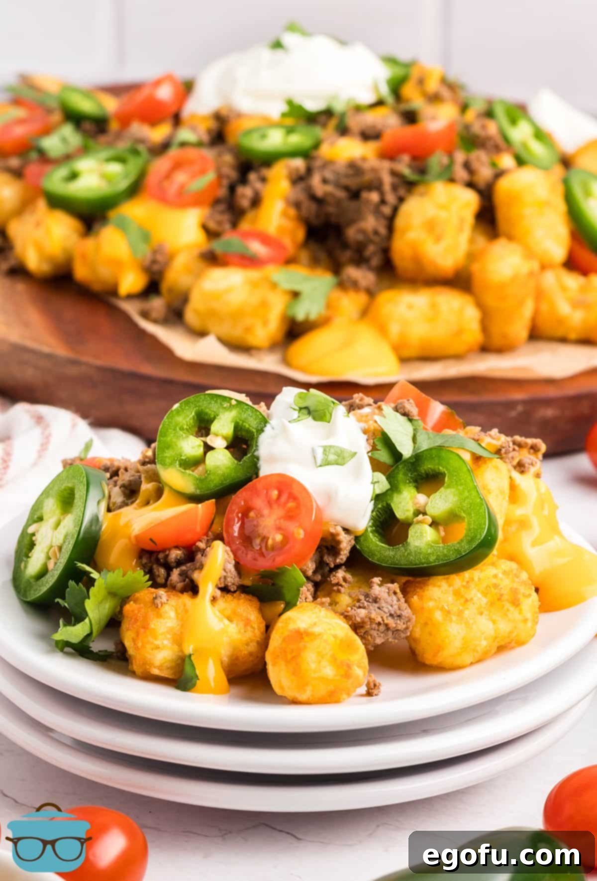 Two distinct serving sizes of Tachos: a large, bountiful platter perfect for sharing at a party, and a smaller, individual portion, both generously topped with seasoned beef, nacho cheese, and fresh ingredients like tomatoes and jalapeños.