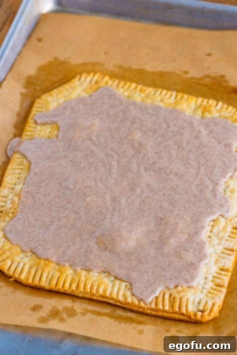 Drizzling brown sugar icing on pop tarts.