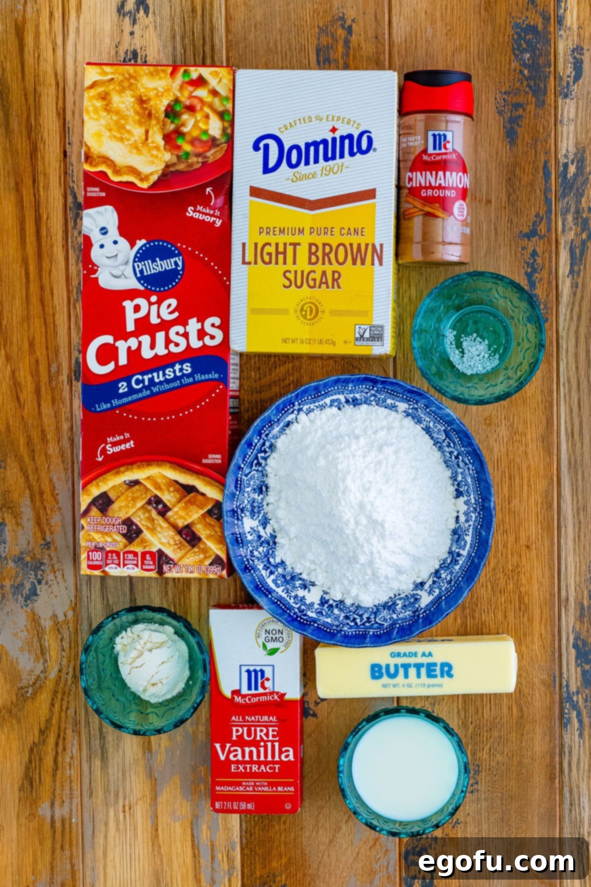 All the ingredients for homemade Brown Sugar Pop Tarts laid out: pie crusts, flour, brown sugar, cinnamon, salt, butter, vanilla, water, powdered sugar, and milk.